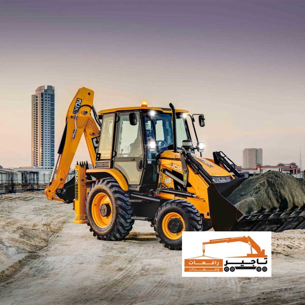 حفار JCB ينقل مواد البناء أمام ناطحات سحاب في مدينة سعودية.