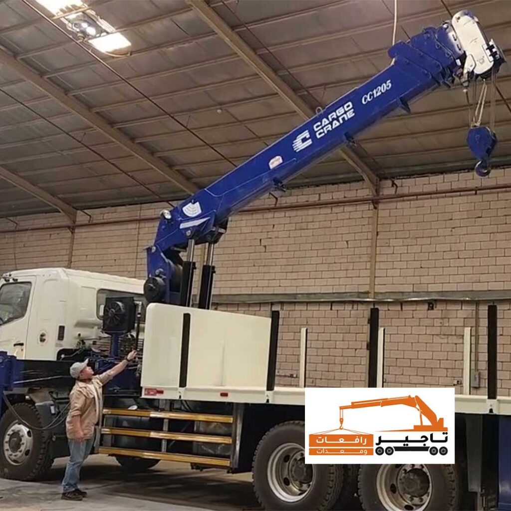 رافعة زرقاء من نوع CARGO CRANE داخل مستودع.